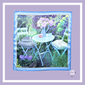 Silk scarf featuring a peaceful garden table with fresh flowers, chairs, and lush greenery, inspired by the original oil painting Urban Zen No. 1 by Flora Do.